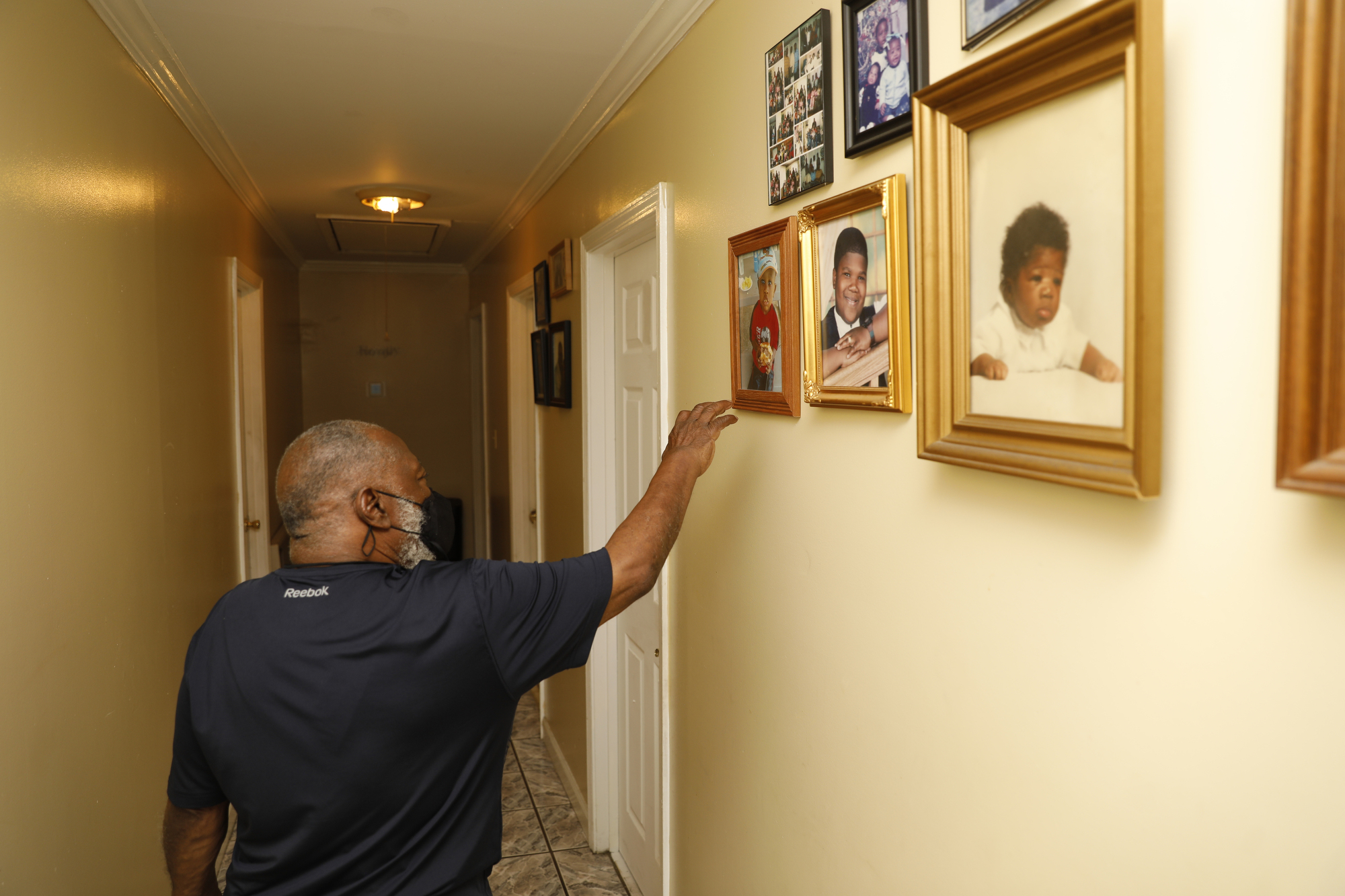 Mabry walks through his hallway lined with family photos. Credit: Octavio Jones for ProPublica